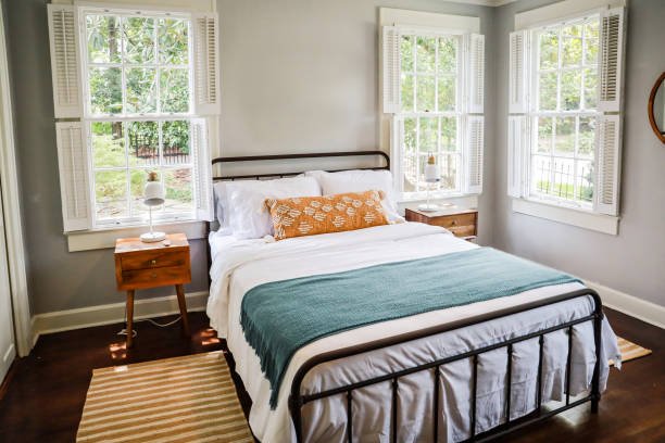A guest bedroom with a queen sized bed and nightstand at a short term rental small cottage style house A guest bedroom with a queen sized bed and nightstand at a short term rental small cottage style house. twin bed stock pictures, royalty-free photos & images