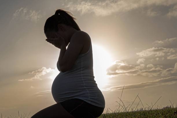 A sad crying pregnant woman suffering from depression. stock photo