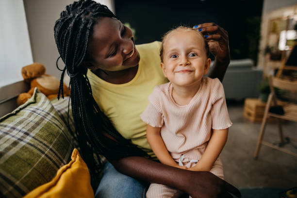 Аdopted daughter with her mother Mother makes a haircut for her daughter adoption stock pictures, royalty-free photos & images