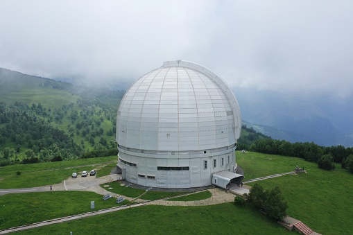 Nizhny Arkhyz, Russia - June 26, 2021: Aerial view of Astrophysical observatory of the Russian Academy of Sciences in Caucasus. BTA tower. Cloudy. Scenic landscape, cosmos, astronomy concept. Summer