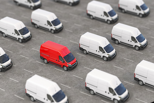 Red delivery van in a rows of white vans. Best express delivery and shipemt service concept. 3d illustration