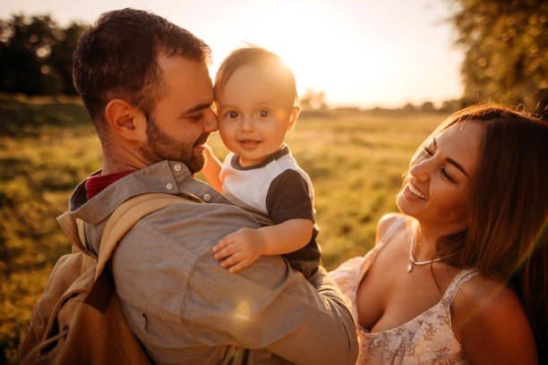 Happy mother, father and sons enjoy nature during sunset