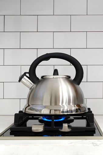 Photograph of a traditional kettle on gas stove waiting for the water to come to a boil