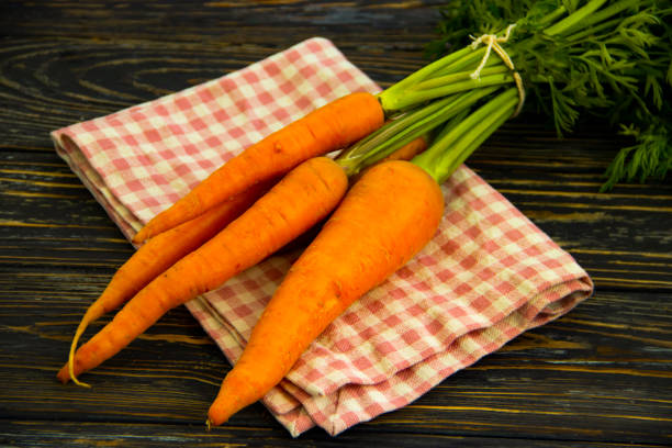 istock fresh whole carrots on wooden background 1336945675