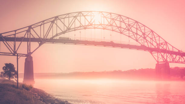 Sunrise over Bourne Bridge spanning over the foggy Cape Cod Canal. The Bourne Bridge in Bourne connects the Cape with the mainland of Massachusetts through Route 28. cape cod photos stock pictures, royalty-free photos & images