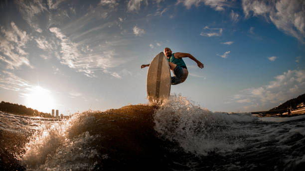 istock athlete effectively jumping over the wave on the wakeboarding board 1336950110