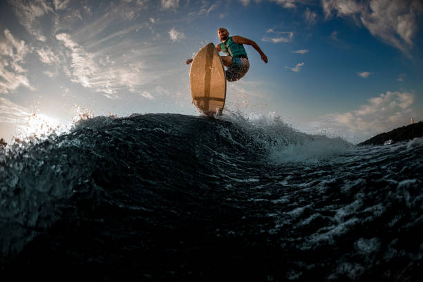 istock magnificent bottom view of male wakeboarder while jumping over splashing wave 1336950137