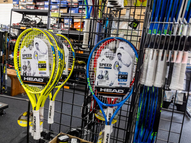 view of tennis racquets for sale inside a play it again sports shop. - racket ball indoors competition imagens e fotografias de stock