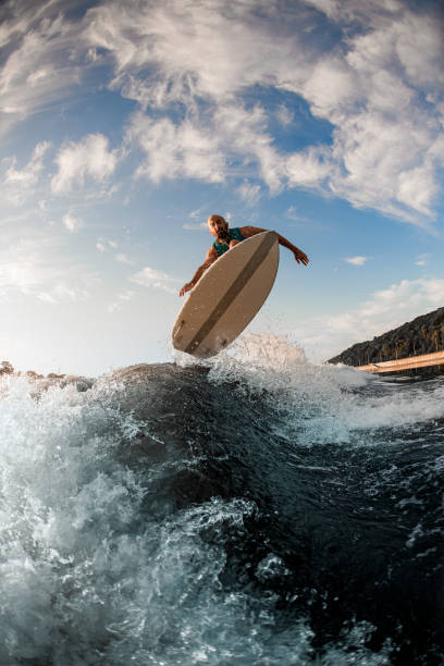 istock view of male wakeboarder while skillfully jumping over splashing wave 1336954097