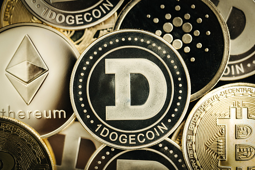 Dogecoin meme coin. Cryptocurrency physical coin close-up, on top of other cryptocurrency coins