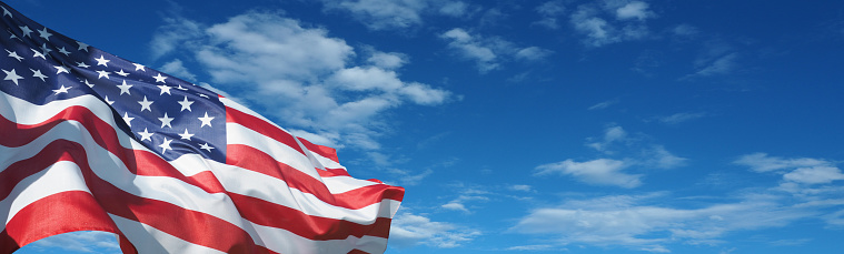 USA flag on a background of blue sky. National holidays concept