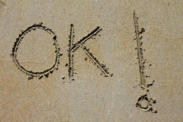istock ok word spell written on beach wet sand 1336960057