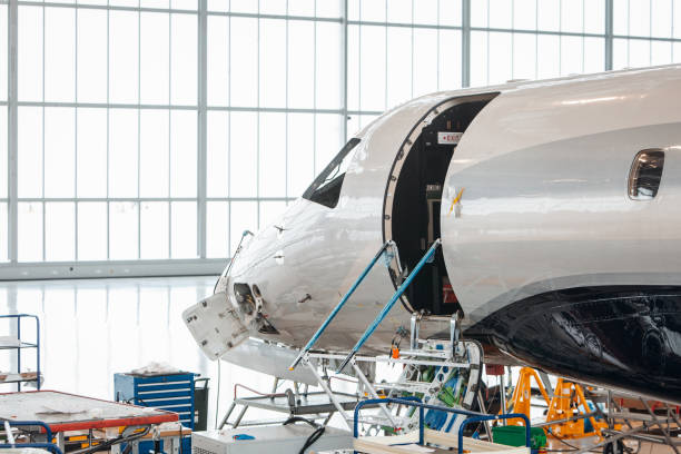 istock Maintenance of airplane in large white hangar 1336961877