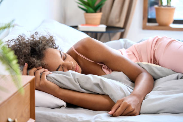 młoda afroamerykanka śpiąca w wygodnej sypialni z zamkniętymi oczami. - deep sleep zdjęcia i obrazy z banku zdjęć