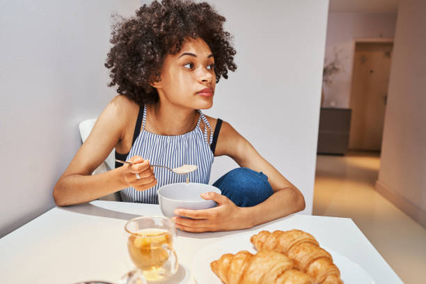 istock Woman sitting at the kitchen table during the morning meal 1336962128