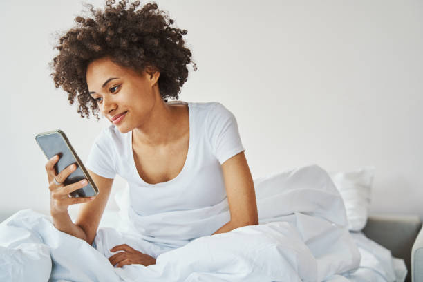 istock Pleased serene woman reading a text message in bed 1336962143