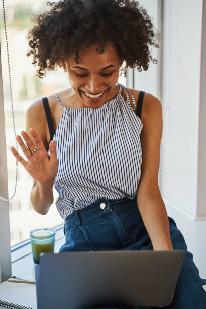 istock Pleased cute female greeting someone on Skype 1336966298