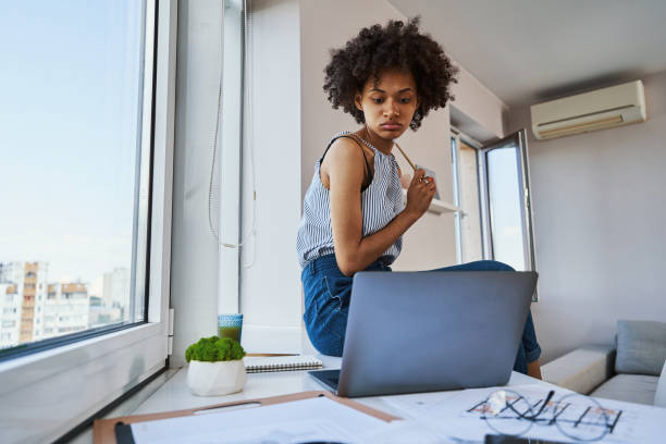 istock Dark-haired young draftswoman staring at her laptop 1336966302