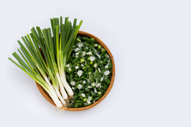 istock Chopped spring onions in bamboo basket on white background 1336968228