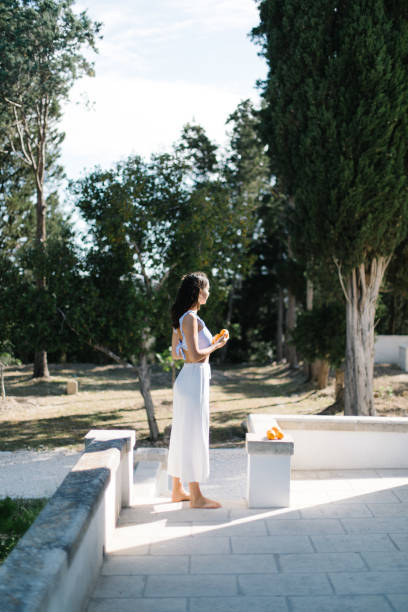 Young woman eats oranges in a garden setting