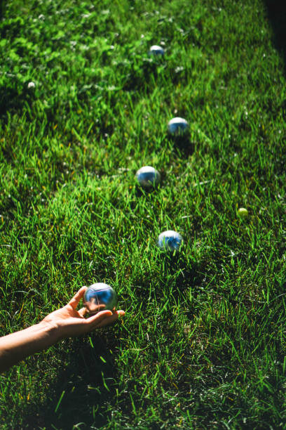 istock Hand rolling boules ball on a green meadow 1336974809