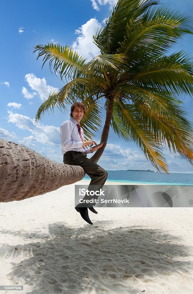 Uomo d'affari con tablet pc seduto su Palma - Foto stock royalty-free di 20-24 anni