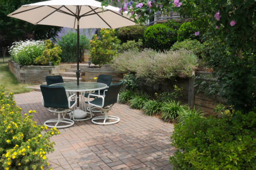 Secluded patio surrounded by flower gardens.