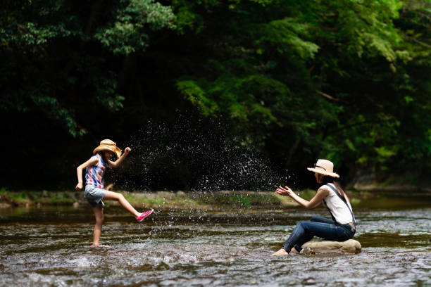 istock Mother and daughter playing in the river 1336980564