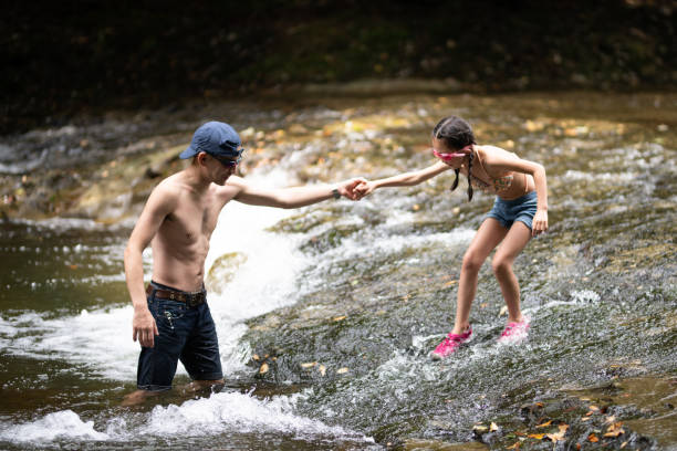 Father and daughter playing in the mountain stream