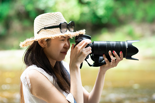 A woman shooting with a single-lens reflex camera