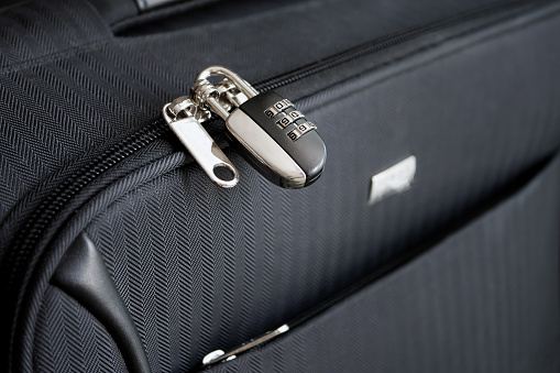 Closed combination lock on suitcase. Closeup of padlock locked on case, Safe travel concept.