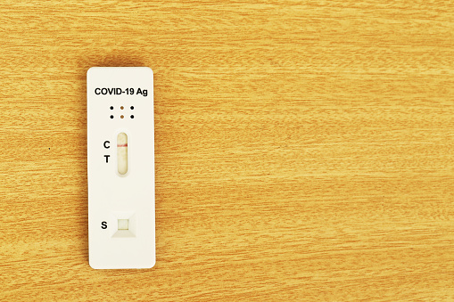 Placing a covit 19 test strip on a brown floor