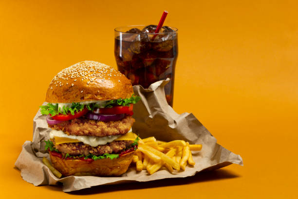 istock Chicken burger with cola and potato fries on a orange background 1336993665