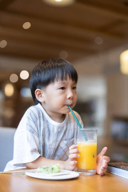 istock The little boy is drinking juice and eating dessert 1336995446