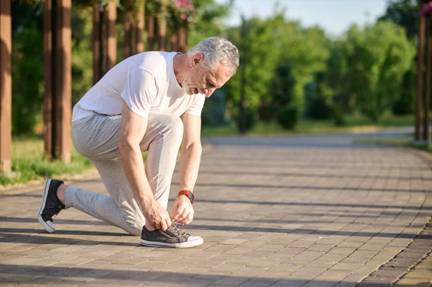 istock A mid aged man in sportswear lacing his snickers 1336998377