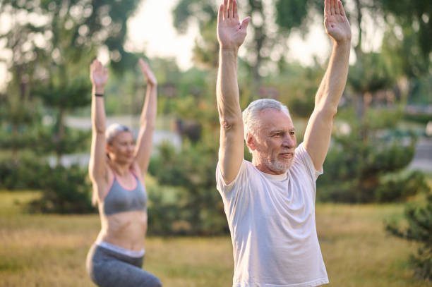 istock Two sportive mature adults exercising in the park 1336998399