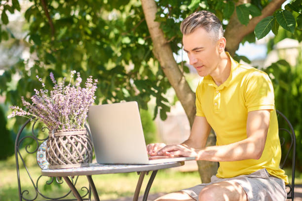 istock Man working on laptop at home in garden 1337001376