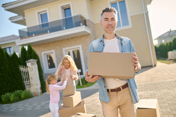 istock Man with box wife with daughter behind 1337001396