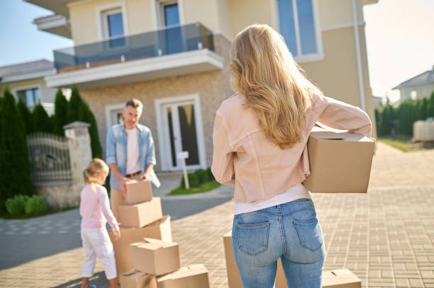 istock Woman with box heading to husband with daughter 1337001401