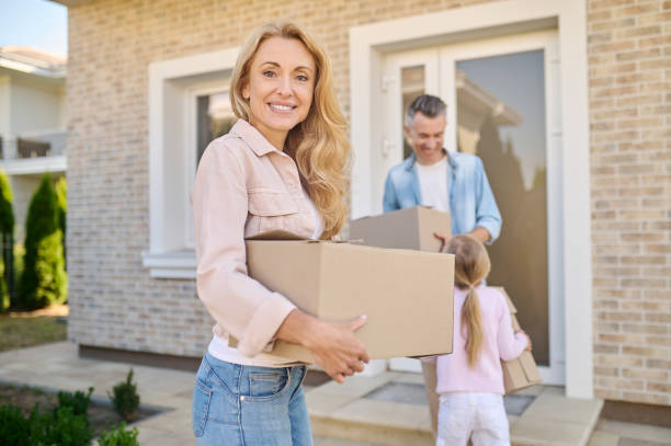 istock Joyful woman with box and husband with daughter 1337001428