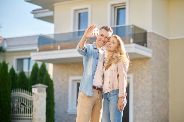 istock Man with house sign hugging his wife 1337001462