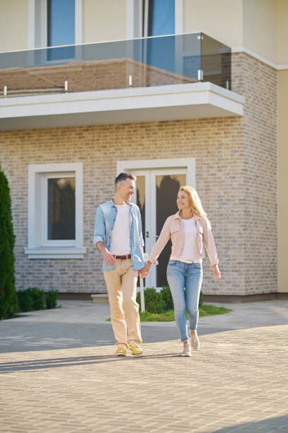 istock Smiling man and woman walking holding hand 1337001485