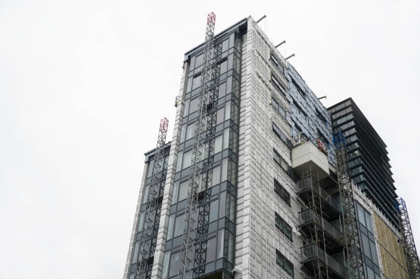 High rise residential building of flats with cladding being replaced with fire resistant materials High rise residential building of flats with cladding being replaced with fire resistant materials UK cladding construction equipment photos stock pictures, royalty-free photos & images