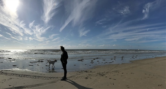 Pregnant woman with here dog at the IJmuiden beach