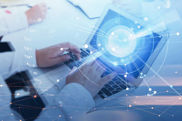 istock Businessman hands with laptop on office table, digital globe with network circuit 1337006625