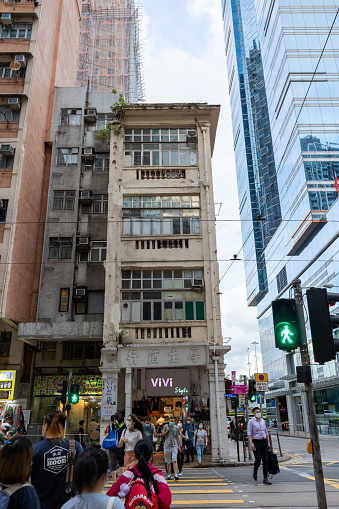 Hong Kong, China - August 25, 2021 : People walk past the 207 Des Voeux Road West in Sai Ying Pun, Hong Kong. The historic building at 207 Des Voeux Road West was built in the 1920s, which is now listed as a Grade II Historic Building in Hong Kong.