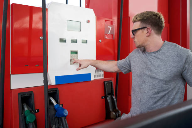 junger kaukasischer fahrer mit sonnenbrille, der die nummer auf tankmaschine von tankstellen drückt, um pickup-truck zu betanken. - gasohol stock-fotos und bilder