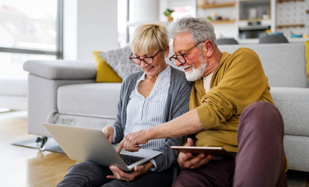 istock Cheerful senior couple using technology devices and having fun at home 1337012001