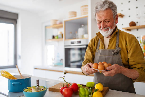 Mature handsome man cooking in home kitchen