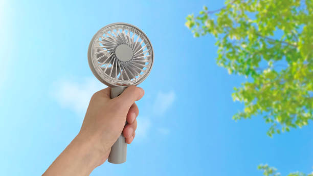 istock Portable electric fan held in the left hand 1337015087